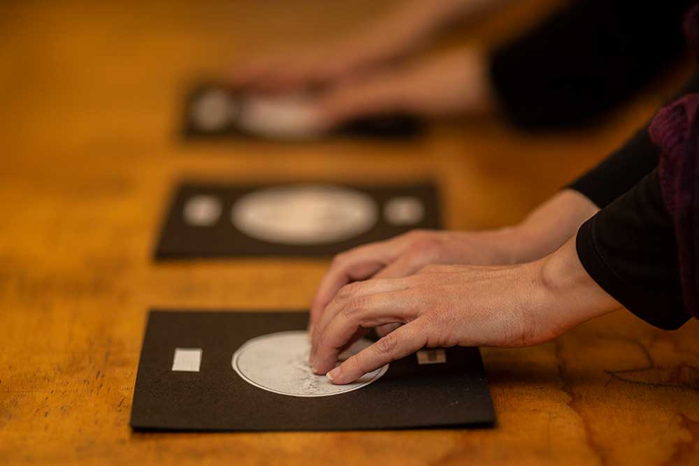 Hands touching 2d models of astronomical objects